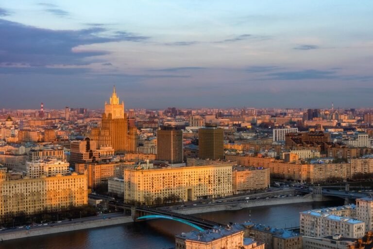Eastern Europe city skyline with modern financial district and stock market data overlay