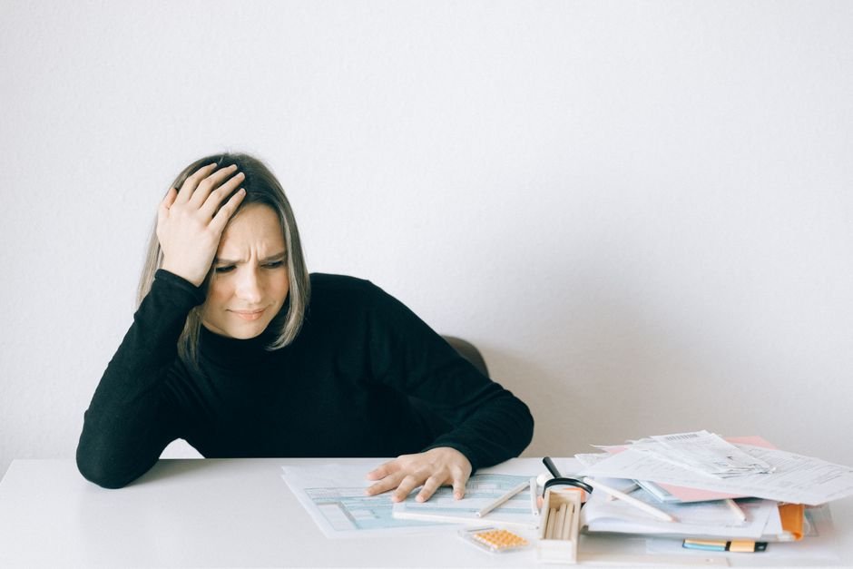 Stressed German taxpayer surrounded by tax paperwork and Freistellungsauftrag forms