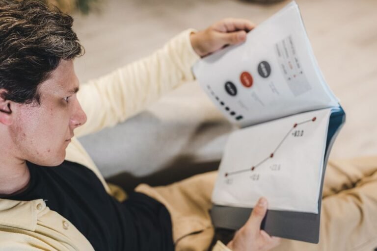 German speaking investor reading financial documents and analyzing market data at office desk