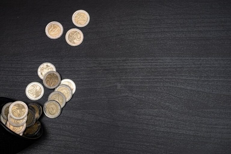Headphones and euro coins symbolizing the best investing podcasts in Europe for financial growth