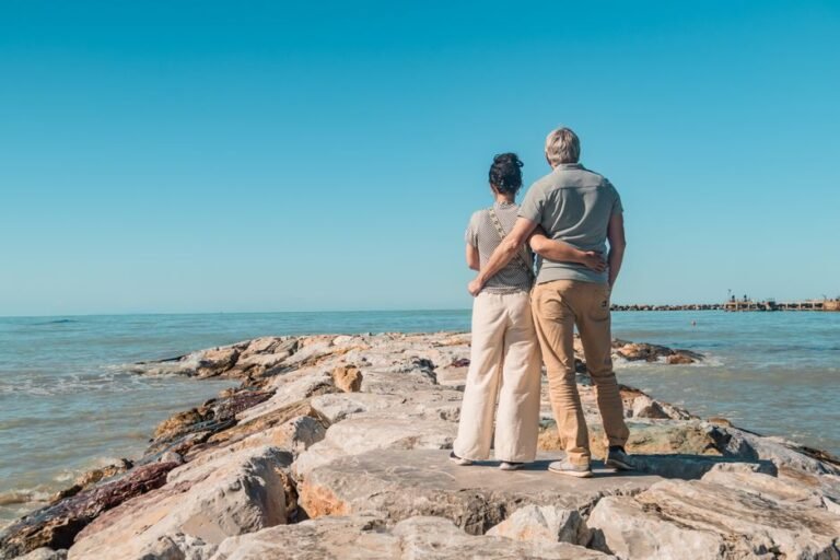 European early retirement dream - couple relaxing on Mediterranean coast representing FIRE financial independence