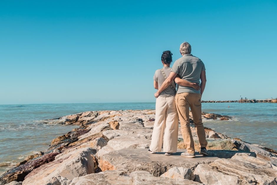 European early retirement dream - couple relaxing on Mediterranean coast representing FIRE financial independence
