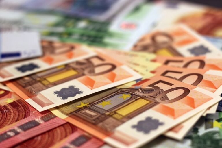 European millionaires reviewing investment portfolio with advisor in modern office