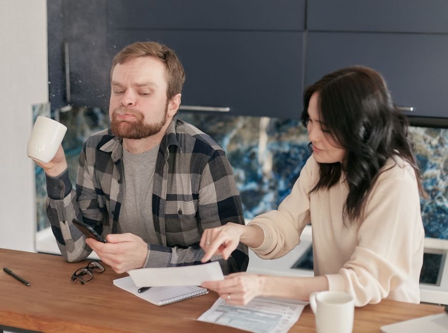 European family reviewing finances at kitchen table, learning how Europeans build wealth through smart money habits