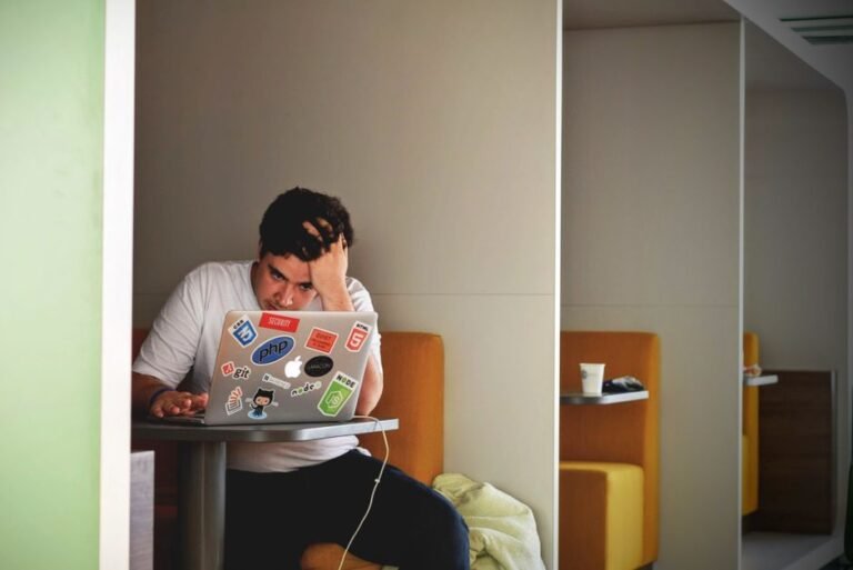 Worried young European professional checking retirement savings and investments on laptop screen