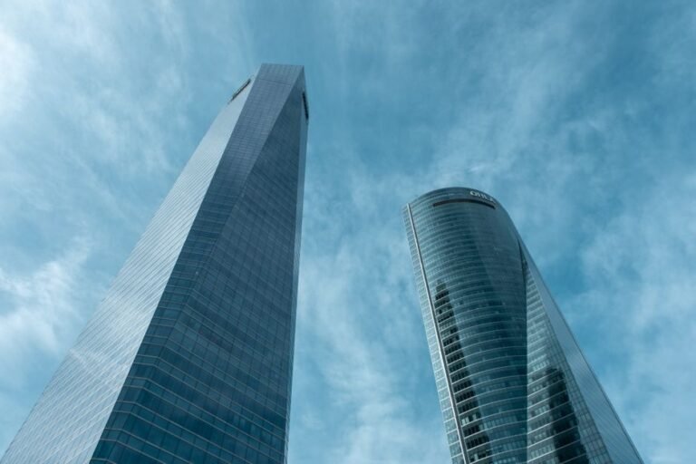 Aerial view of the AZCA financial district in Madrid, Spain, showing modern skyscrapers and busy streets.