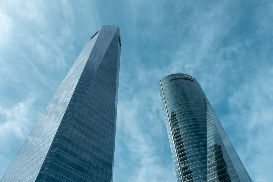 Aerial view of the AZCA financial district in Madrid, Spain, showing modern skyscrapers and busy streets.