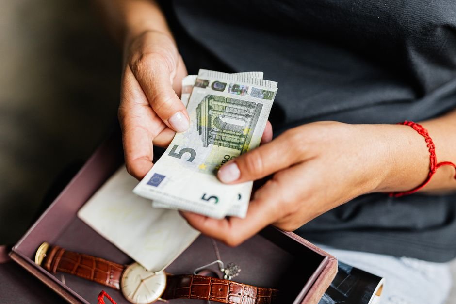 Person carefully counting euro banknotes while learning how to invest first 1000 euros