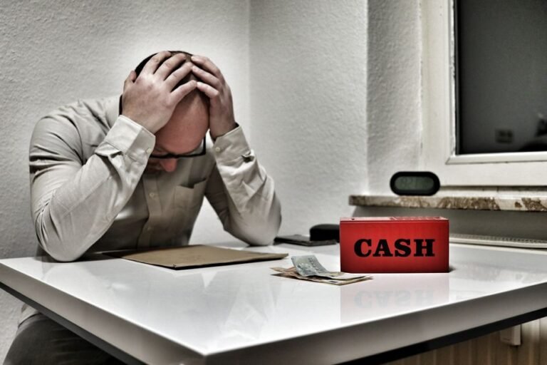 Worried European checking savings account balance on laptop at home