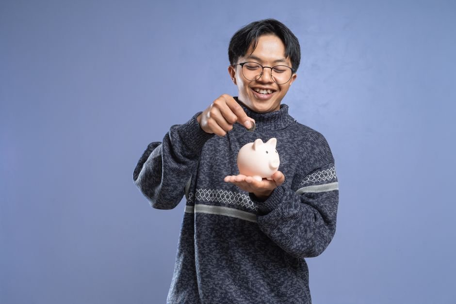 Young person saving money in a jar to start investing with 500 euros