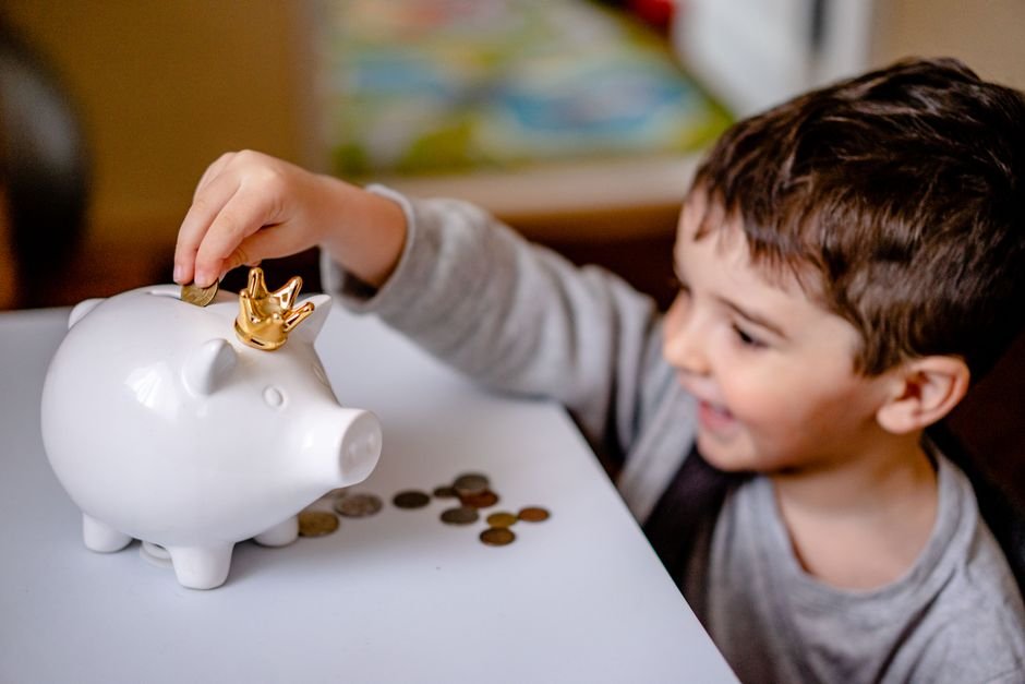 Child looking at piggy bank representing junior investing account Europe for kids savings