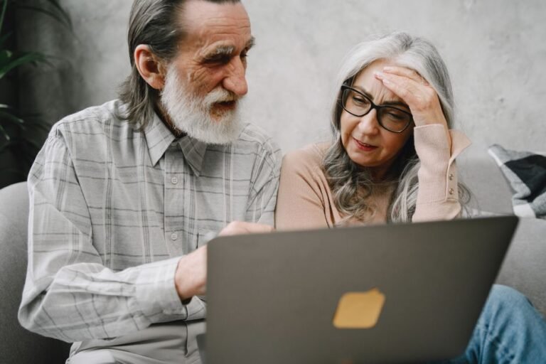 Couple looking at laptop confused while deciding whether to buy a house or invest in ETF Europe