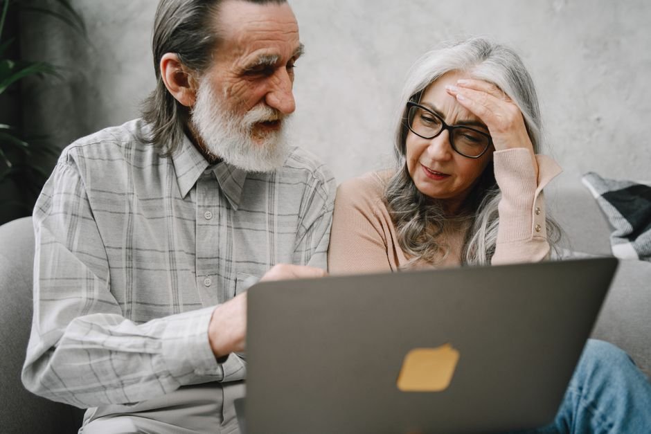 Couple looking at laptop confused while deciding whether to buy a house or invest in ETF Europe