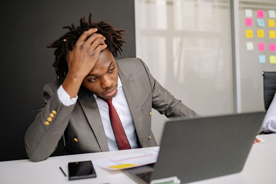 Worried investor looking at laptop screen showing falling stock market data, concerned about broker bankruptcy in Europe